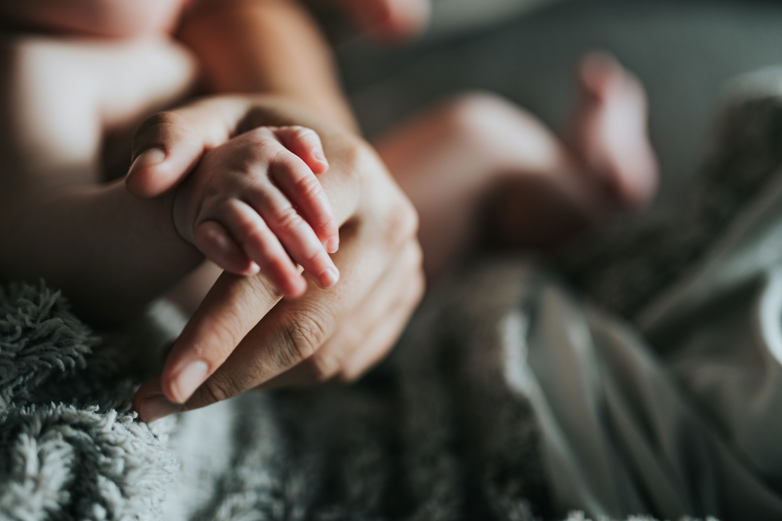 Person holding baby's feet